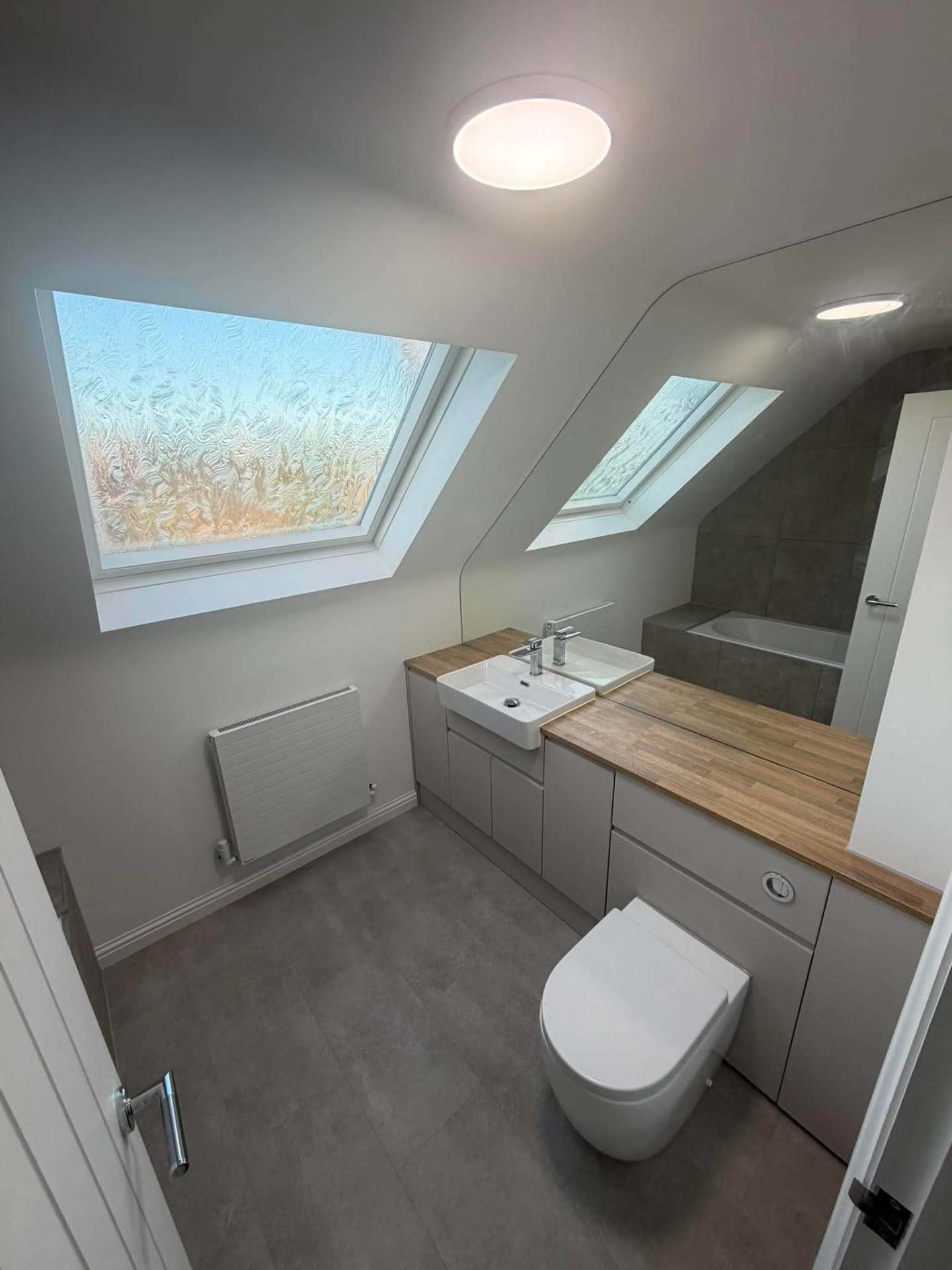 Loft bathroom with skylights, fitted vanity and oak worktop